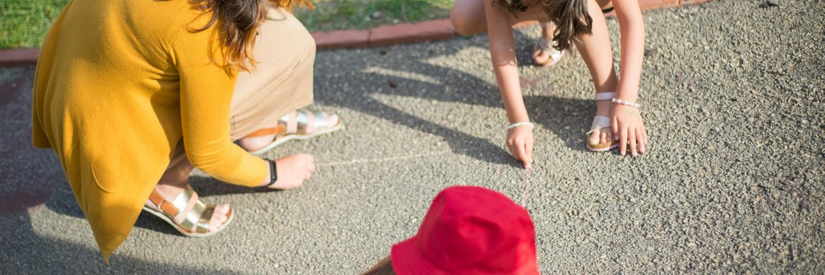 Kinder mit Mutter malen Straßenmalkreide